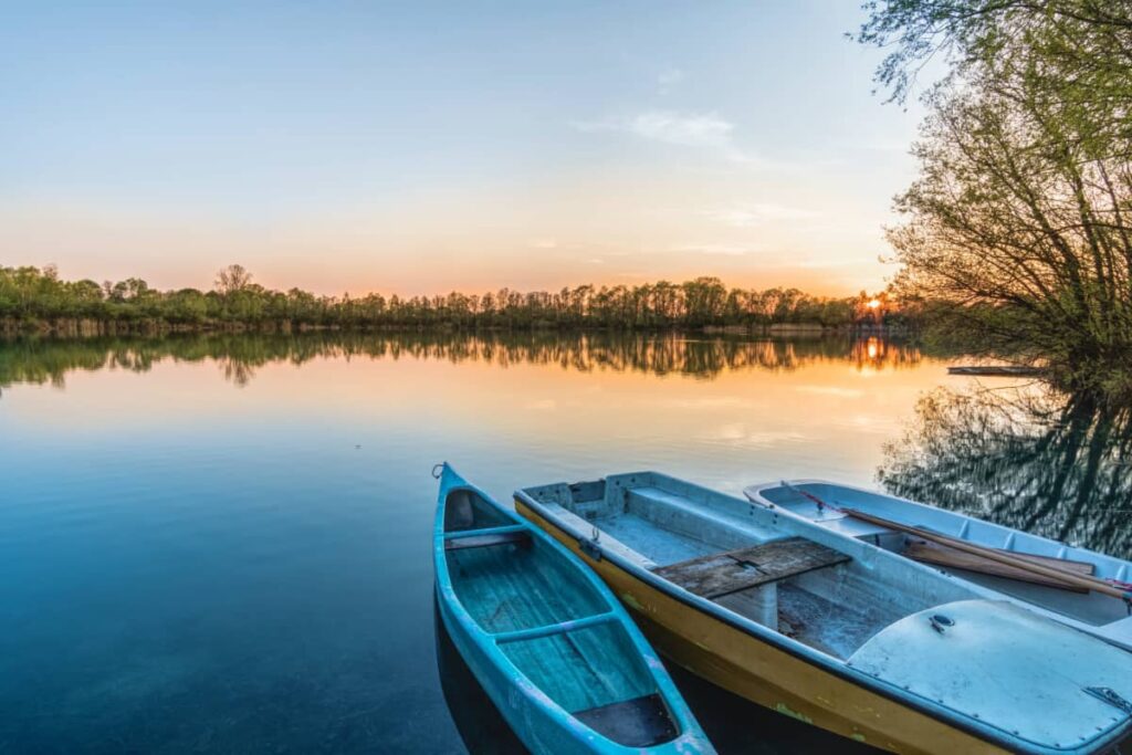 a blue canoe on the shore of a lake