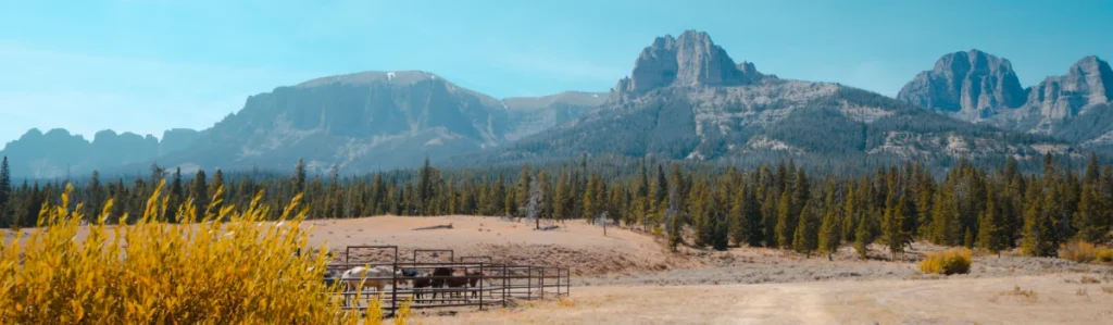 A photo of mountain peaks and a horse corral in the Wind Wiver Range of Wyoming