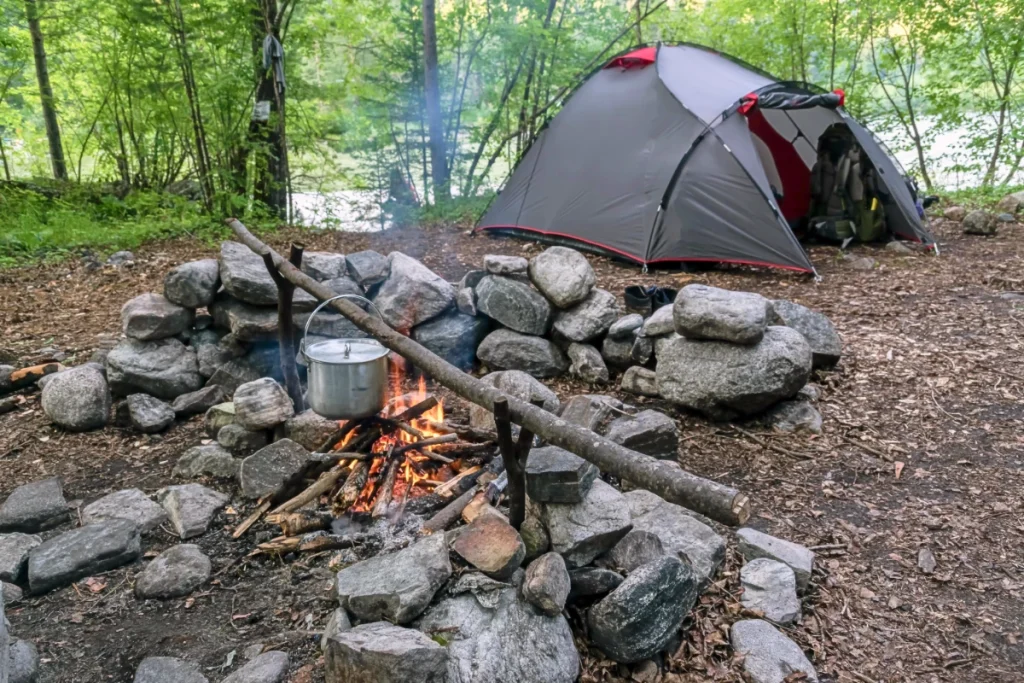 a photo of a tent next to a fire pit following the theme of 10 camping hacks