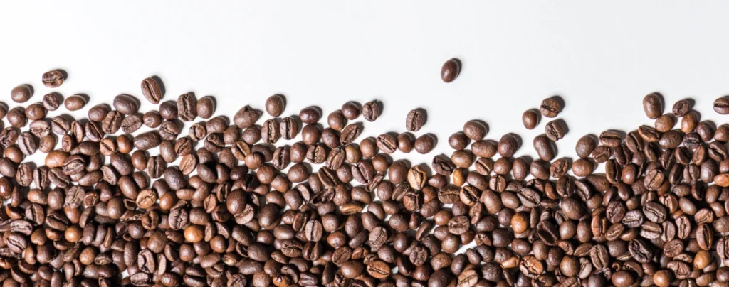 a photo of coffee beans on a white table. used in this article as an accent photograph